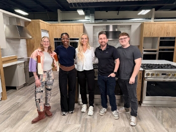 Chrysalis standing next to the team on set for an appliance store commercial.