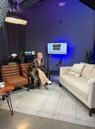 Image shows Chrysalis sitting on a couch in the set for a podcast