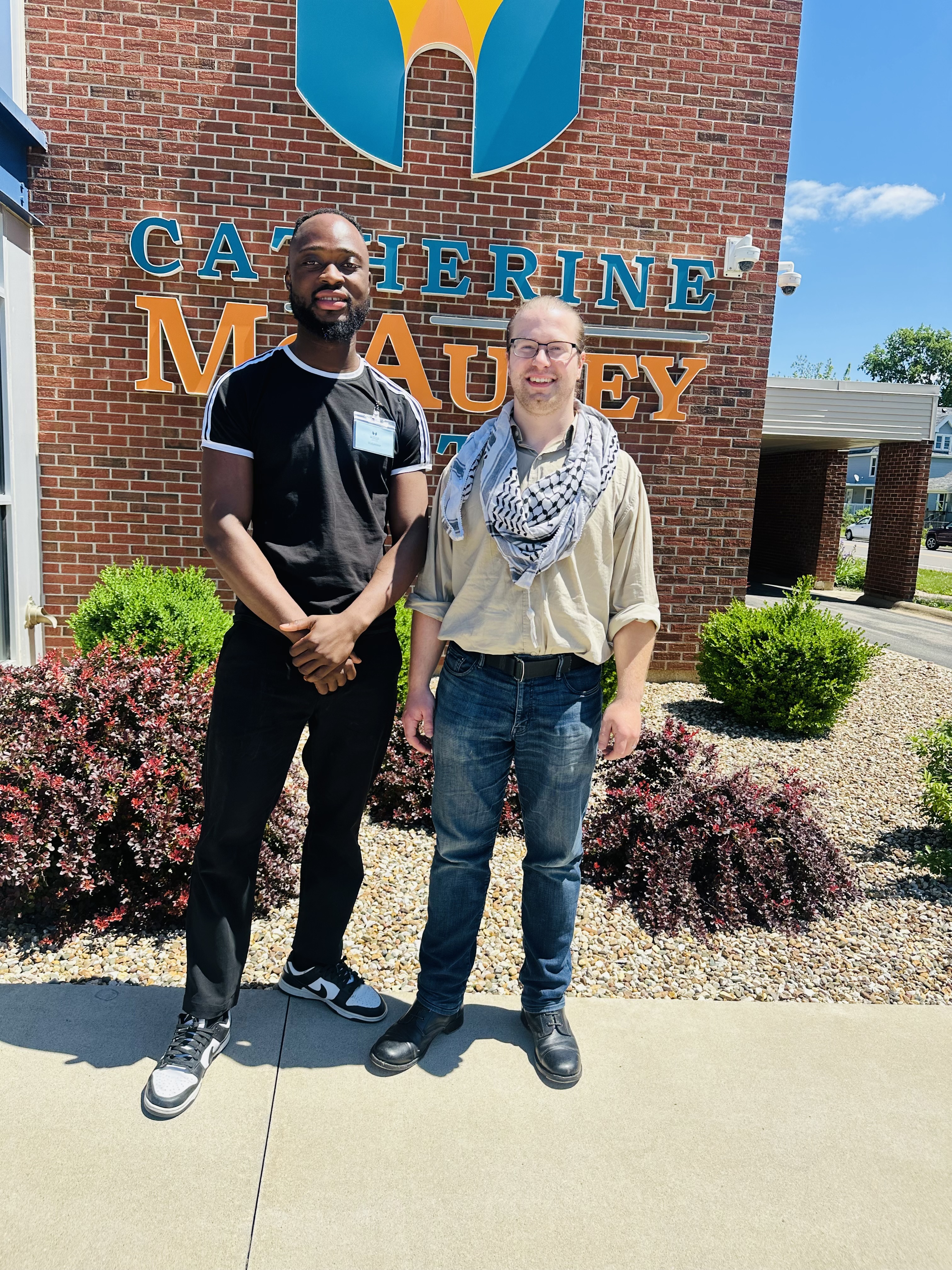 Intern and supervisor stand outside a building.